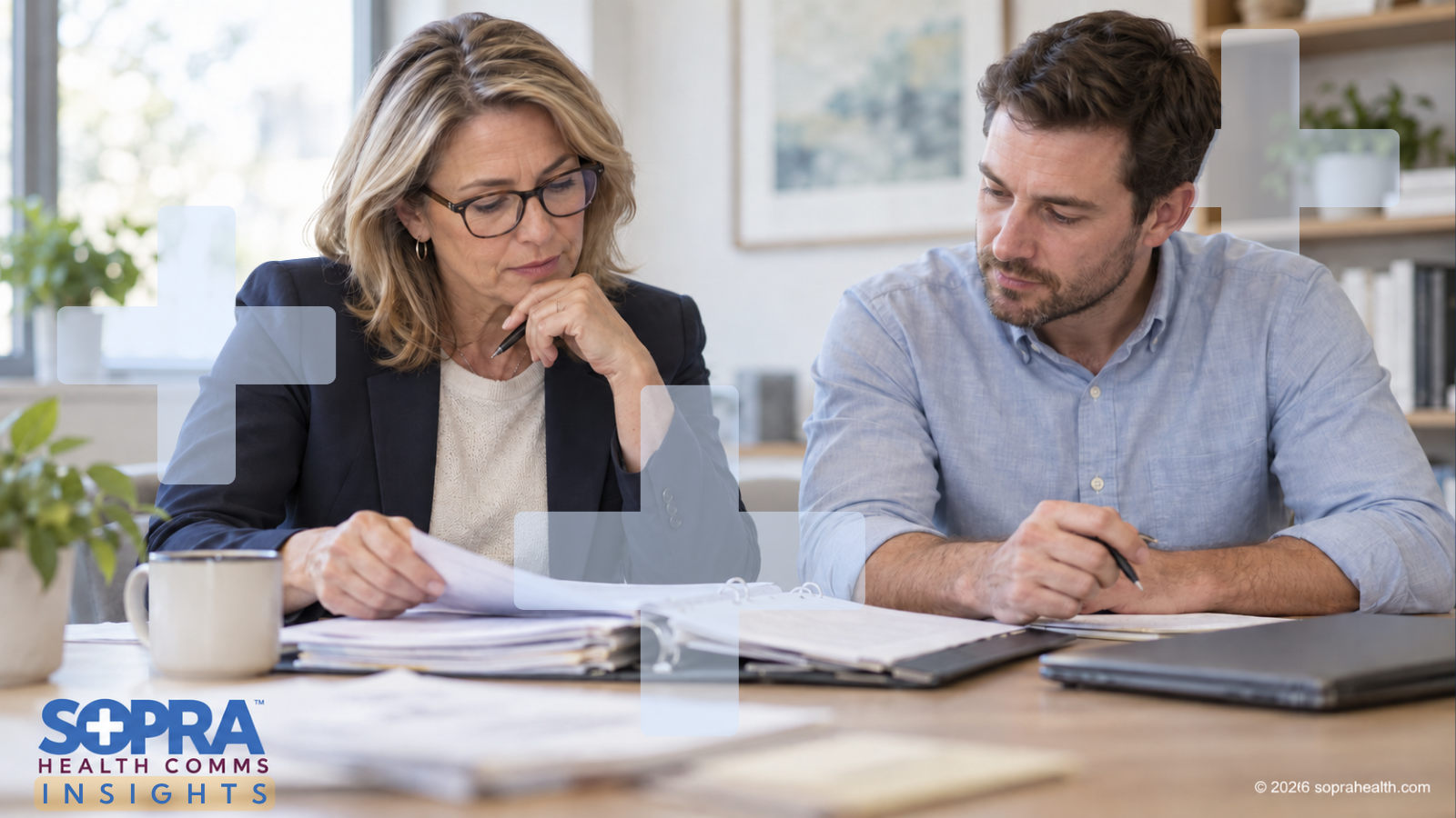 Two people reviewing a content binder while sitting at a table - 109 hero sopra health insights